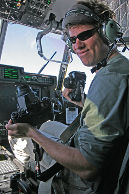 Author / Photographer Ed Darack holding two of his cameras in the right seat of a Marine Corps KC-130J flying thousands of feet above the Al Anbar Province of Iraq. Copyright Ed Darack; Permission granted for use in media products about / related to Ed Darack's creative work. width=